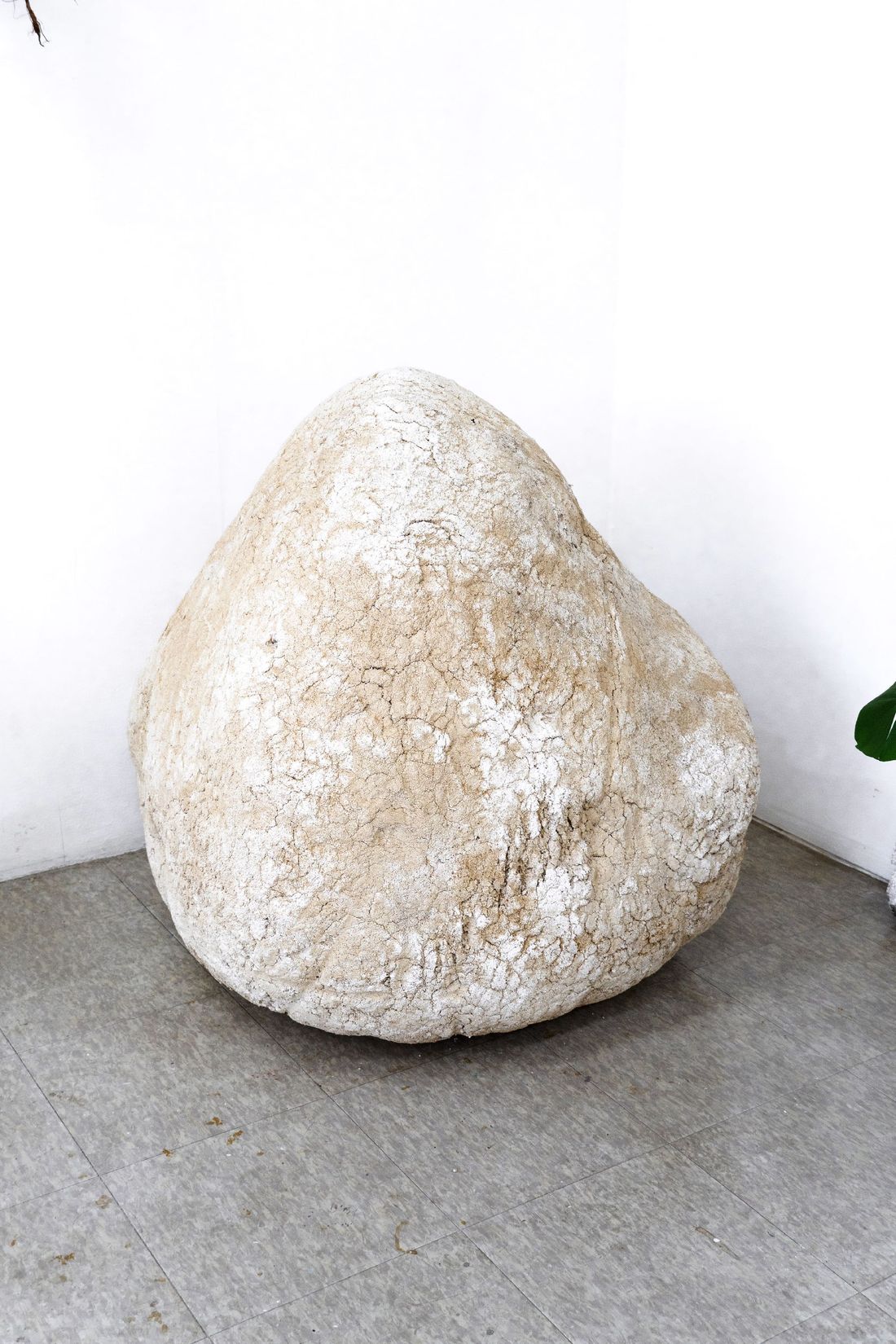 A large pale rounded New Rock resting on a plinth