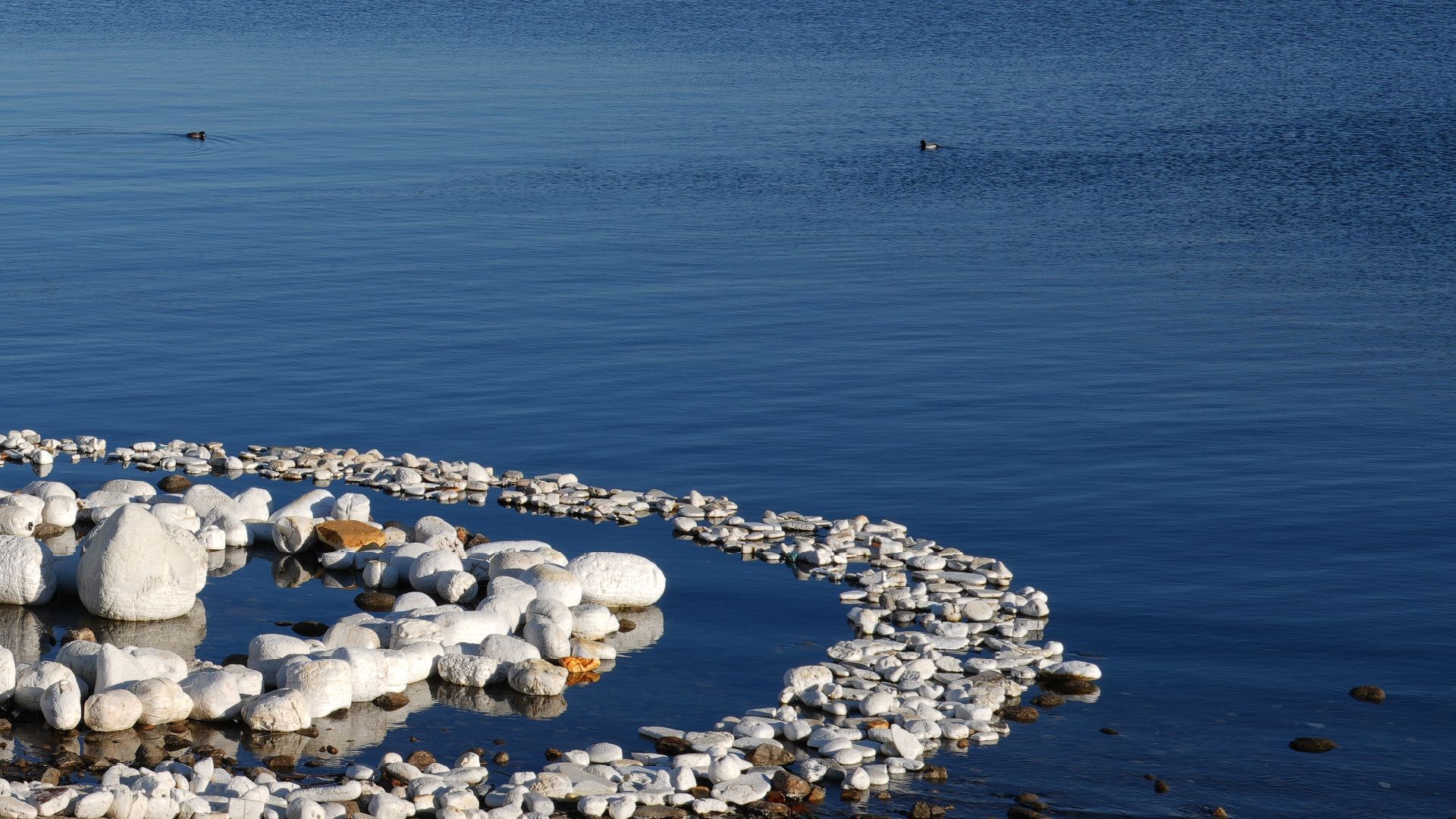 Aerial view of a large spiral of white New Rocks floating on the surface of Cheongchoho lagoon